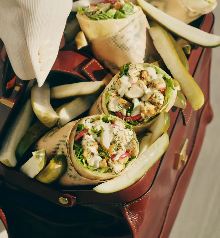 A leather briefcase packed with Molly's Big Dill Caesar Wraps and whole pickle spears