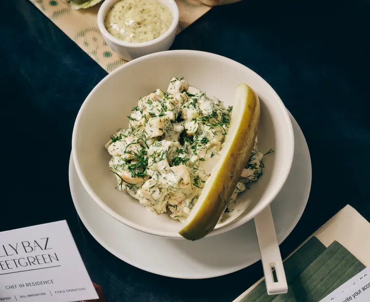 Molly's Double Chick Scoop, two scoops of creamy dill chicken salad in a white bowl with a pickle spear on the side